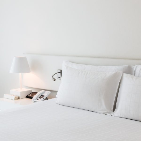 White pillow on bed with table light lamp decoration in bedroom interior